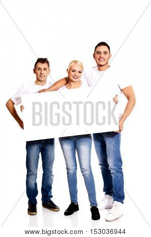 Group of happy friends holding empty banner