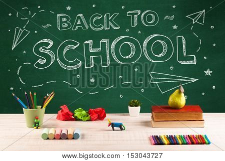Back to school concepty with writing on blackboard and desk, apple, books, items