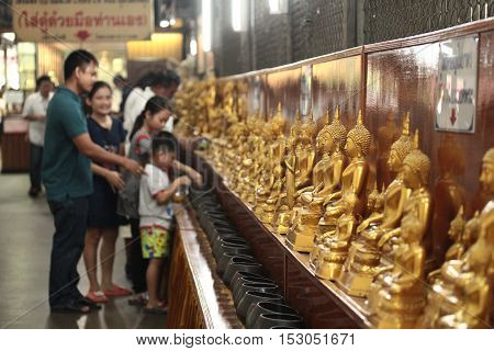 Chachoengsao,Thailand-October 15,Family pay coins in 109 monk bowls next Buddha images in Buddhist worship way at Wat Sothon Wararam Worawihan on October 15,2016 ,Thailand. Selective focus.