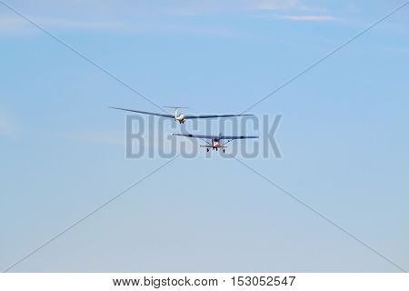 A sailplane in front of a blue sky glides through the air without its own motor drive.