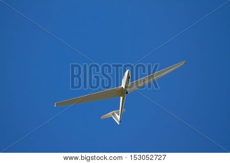 A sailplane in front of a blue sky glides through the air without its own motor drive.