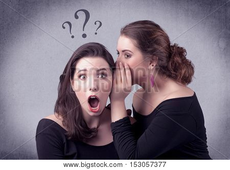A teenager girl looking confused with drawn question marks above the head, while a girlfriend whispers something in her ear concept.