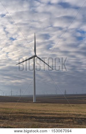 Eolian field and wind turbines farm on a cloudy day