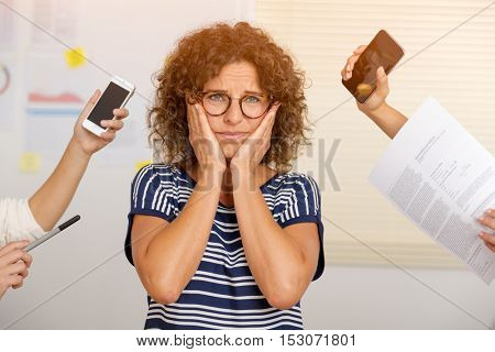 Creative concept of a ver busy middle age woman at the office full of work
