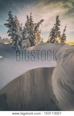 Fantastic orange evening landscape glowing by sunlight. Dramatic wintry scene with snowy trees. Kukul ridge, Carpathians, Ukraine, Europe. Toned like Instagram filter