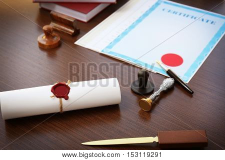 Tied scroll with old notarial wax seal and stamp on table