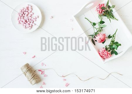 Workspace. Rose flowers. Flat lay top view