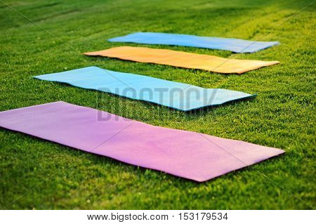 four yoga mats on the green with fresh grass