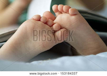 Foot closeup. An image of a toddler reading a book.