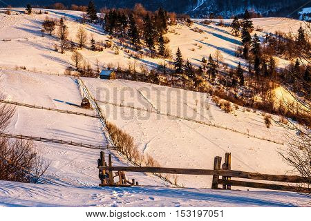 Fence On Snowy Mountain Slope Near The Forest In Winter