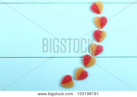 jelly hearts four pieces on turquoise on a wooden background