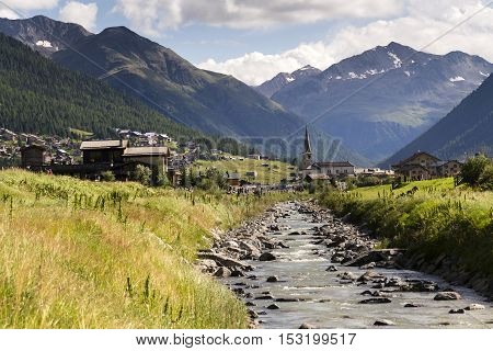 Spol River With Church Of Santa Maria In Livigno, Italy