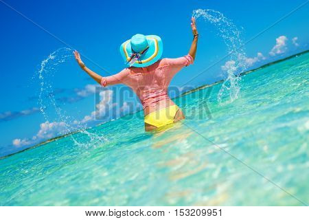 Woman in bikini having fun on the beach in Exuma, Bahamas
