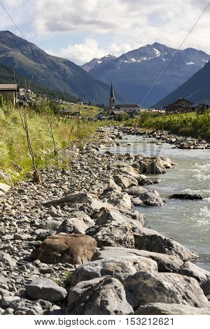 Spol River With Church Of Santa Maria In Livigno, Italy