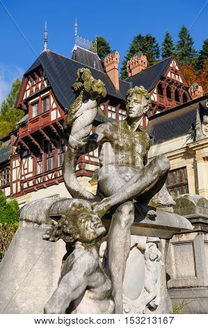 Statue in front of beautiful Peles castle and ornamental garden in Sinaia, Romania, between Valachia and Transylvania