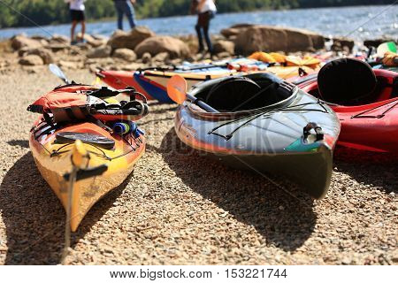 Kayaks on the pebbles at the edge of the lake.