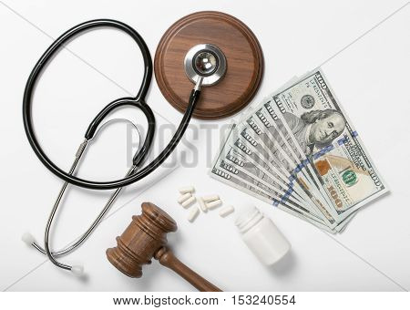 Medical stethoscope pills judge hammer and money on a white background. Concept of bribery in the medical field