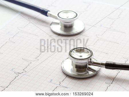 two stethoscope on a white background with cardiogram close up soft light
