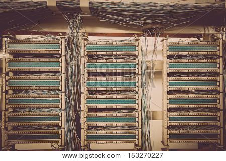 Color image of an old telephone exchange wit many wires.