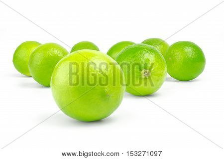 scattering of fresh green citrus limes on white background.