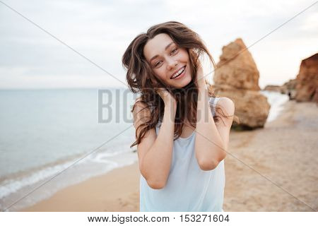 Cheeerful playful young woman having fun on the beach