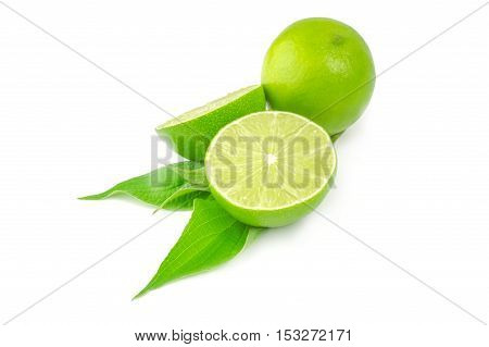 Two halves and whole lime isolated on white background with leaves.