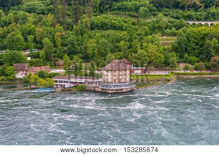 Neuhausen am Rheinfall Switzerland - May 24 2016: Rhine River at Rhine Falls and Castle Woerth in the Neuhausen am Rheinfall in the Canton of Schaffhausen Switzerland. Famous waterfall in Europe. Swiss travel destination and tourist attraction.