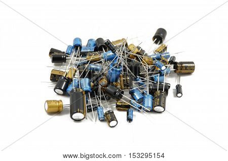 Lots of different capacitors isolated on white background, piled up together