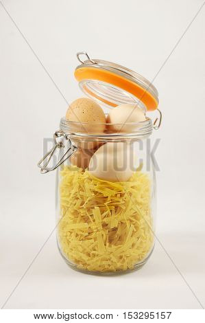 Pasta with eggs in a jar as a concept or metaphor for mixing ingredients