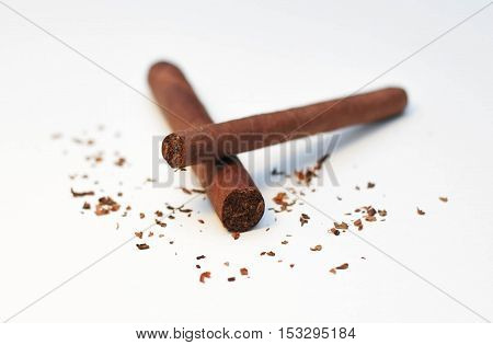 one cigar on top of another on white background