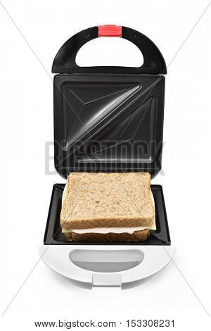 a sandwich ready to be toasted in an electrical sandwich toaster, on a white background