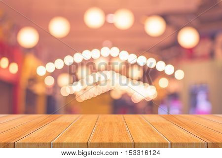 Wooden board empty table top on of blurred background. Perspective brown wood table over blur in coffee shop background - can be used mock up for montage products display or design key visual layout.