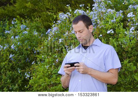 Man on a smartphone playing games outdoors.