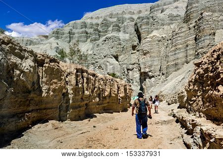 tourists are in the desert along the bed of a dry river