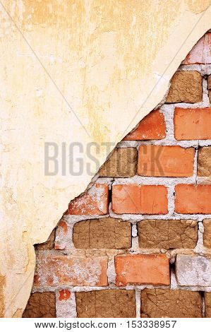 Damaged old brick wall with plaster remains, showing the brick structure, composed of ceramic and old pressed dirt bricks, background, concept, metaphor