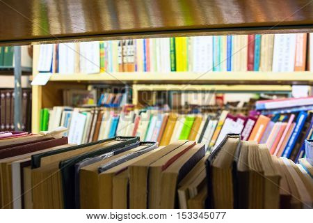 Books on the shelves in the library. Blurred background