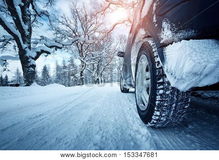 Car tires on winter road covered with snow