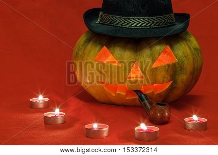 Pumpkin for Halloween with glowing eyes and smoking pipe