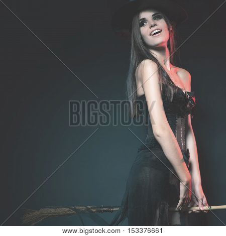 Halloween party 2016. Beautiful woman like witch flying by broom. Fashion. Halloween costumes. Witch carnival costume. Night club. Holiday at October 31, 2016