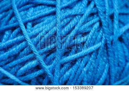 Woolen yarn ball, skein of tangled blue sewing threads, selective foci