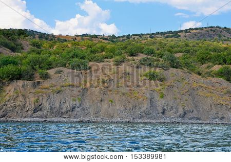 Mountain range with vegetation rises above sea level.