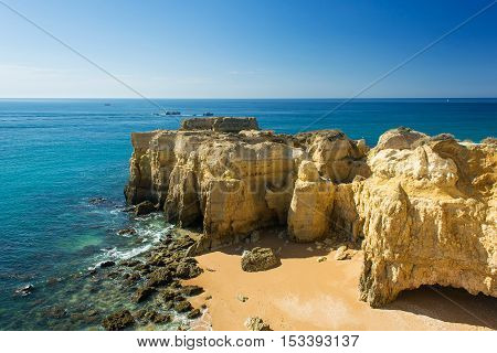 a view of beautiful sandy beach Pria do Castelo on Atlantic ocean with cliff and rock formation in Albufeira Algarve region Portugal