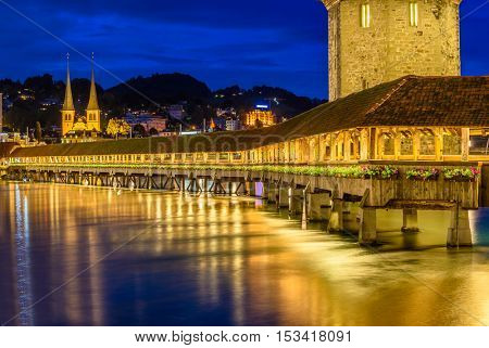 Night view towards Chapel Bridge (Kapellbruecke) together with the octagonal tall tower (Wasserturm) it is one of the Lucerne's most famous tourists attraction