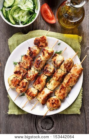 Chicken kebab on white plate top view