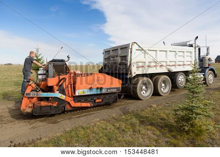 Colbert, WA - October 24, 2016: Workers from Black Diamond Asphalt Paving, LLC., repairing patches and re-paving a private road/driveway