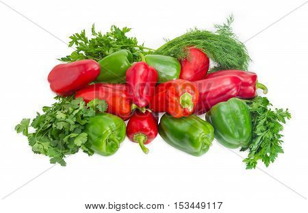 Pile of fresh green and red bell peppers and bundles of parsley cilantro and dill closeup on a light background