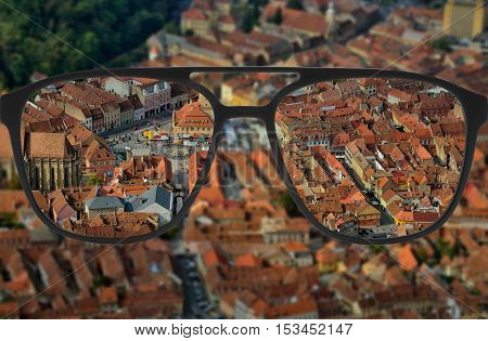 Clear image in glasses against blurry city landscape