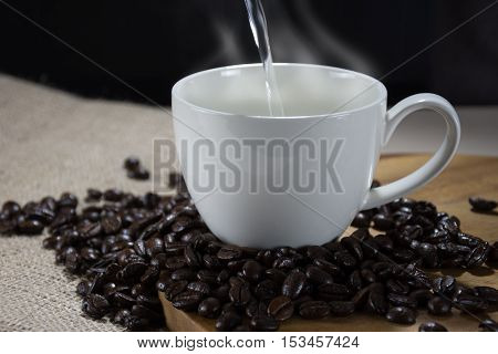 White coffee cup with hot water pouring into