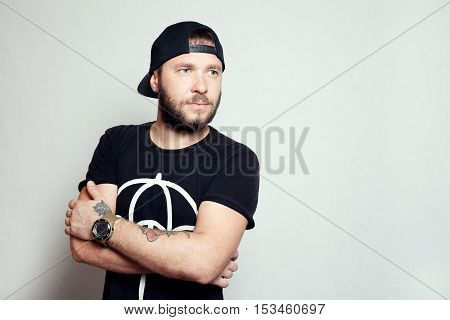 Baerded man in black t-shirt on grey background