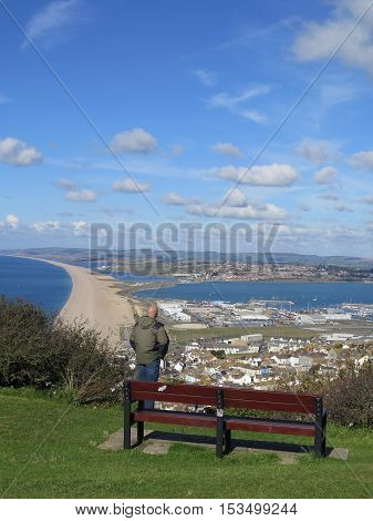 Portland England - October 9 2016: Person viewing the village of Chesil along Chesil Beach a 29 km long shingle beach Dorset England UK